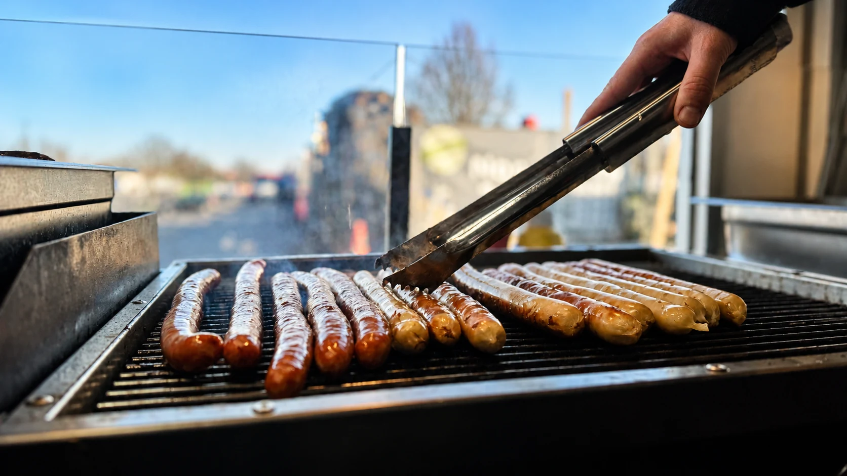 Bratwürste auf dem Grill bei der Zubereitung vor Ort