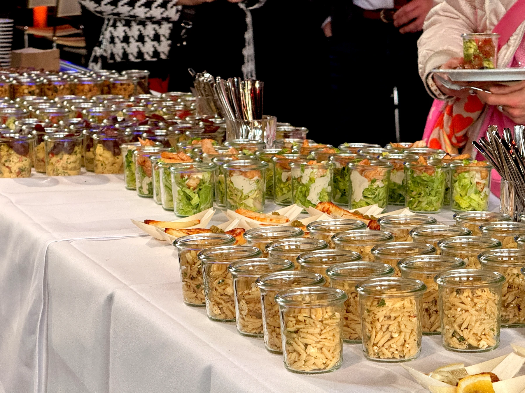 Buffet mit portionierten Salaten in Gläsern und Fingerfood