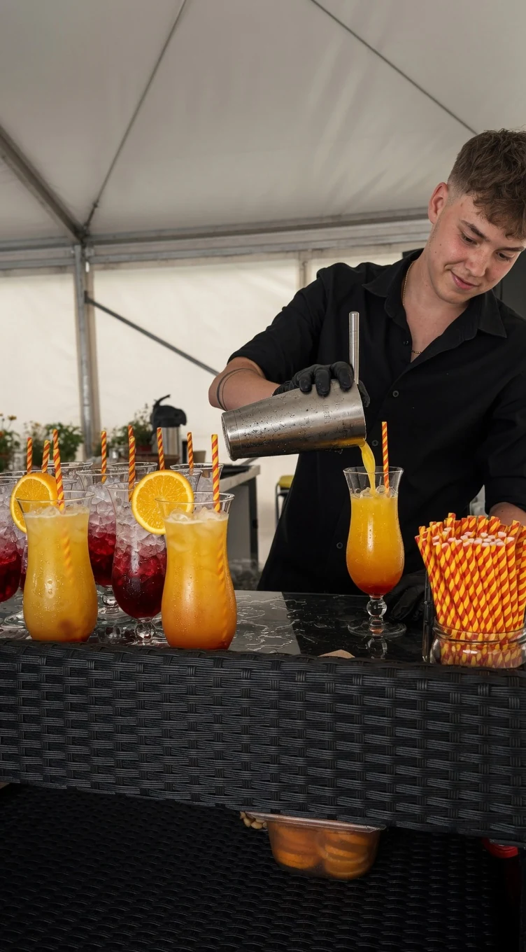 Mitarbeiter schenkt Cocktails an einer mobilen Bar aus